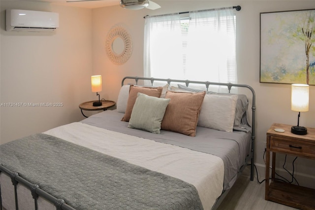 bedroom featuring multiple windows and an AC wall unit