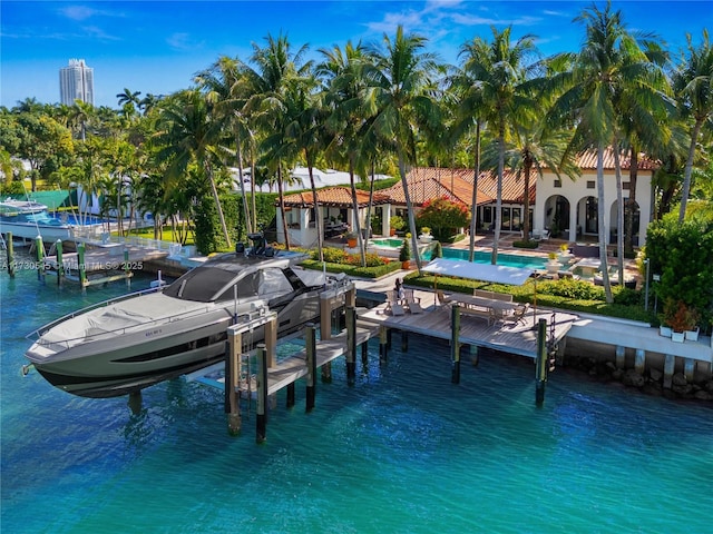 dock area with an outdoor pool, a water view, and boat lift