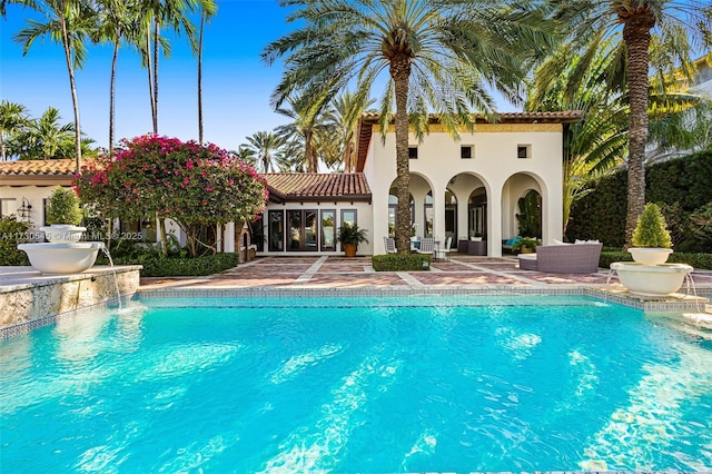 view of swimming pool featuring a patio, outdoor lounge area, and pool water feature