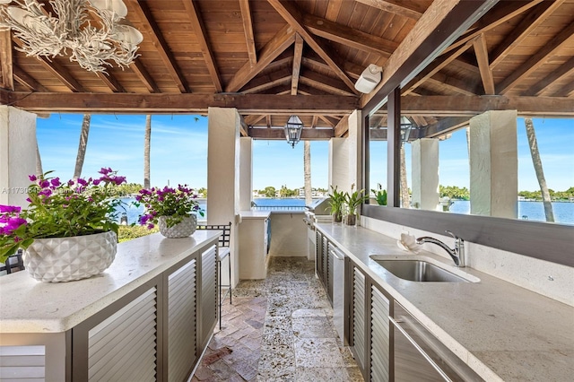 view of patio with sink, a gazebo, an outdoor kitchen, and a water view