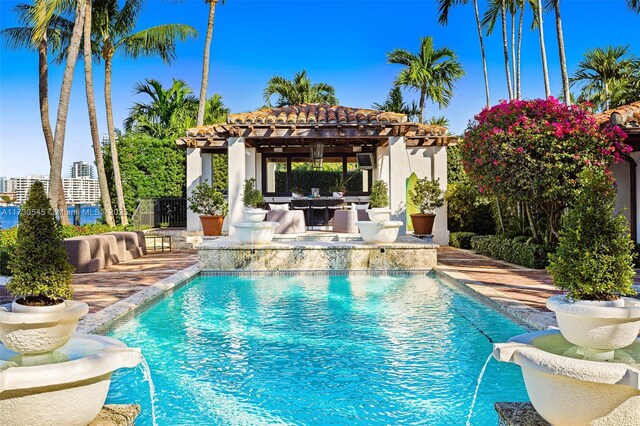 view of pool featuring pool water feature, a patio area, and a pergola