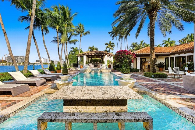 view of pool featuring a gazebo, a water view, and a patio