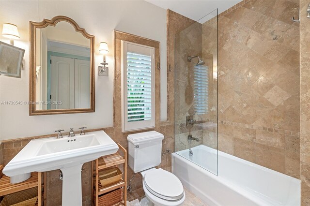 bathroom featuring tiled shower / bath combo and toilet