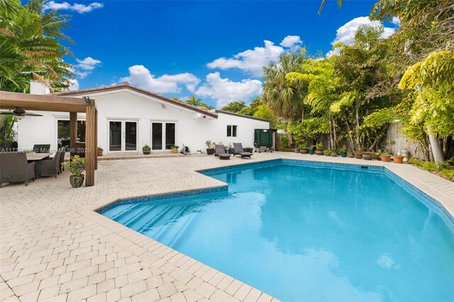 view of pool with ceiling fan and a patio