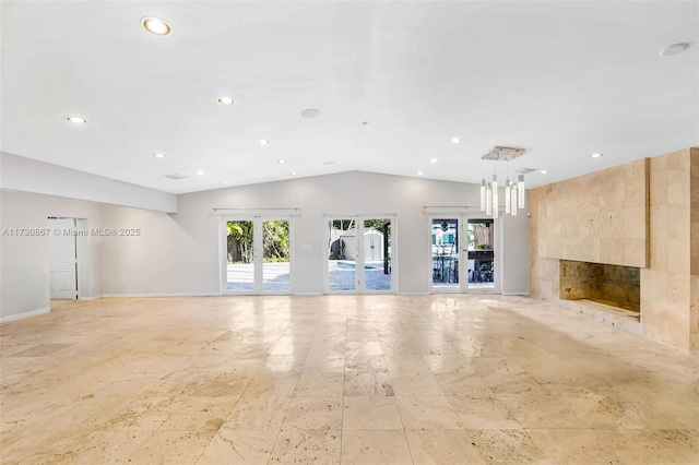 unfurnished living room with french doors, a premium fireplace, and vaulted ceiling