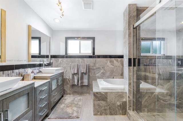 bathroom featuring vanity, independent shower and bath, and a healthy amount of sunlight