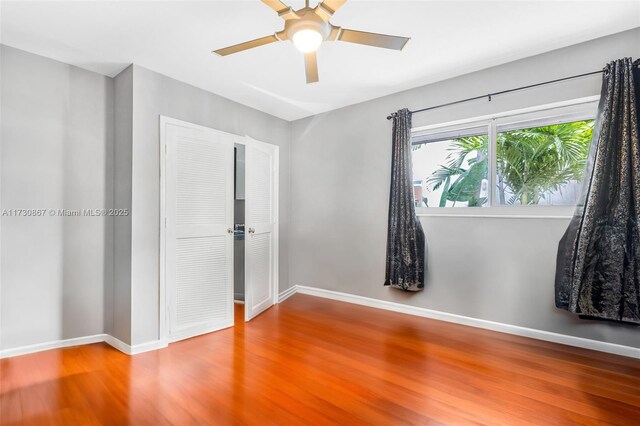 unfurnished bedroom featuring hardwood / wood-style flooring, ceiling fan, and a closet