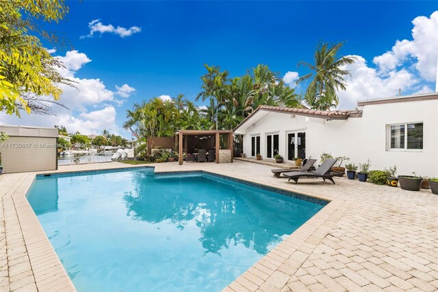 view of swimming pool featuring a patio area and french doors