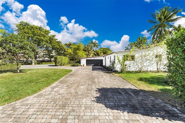 view of front of home with a garage and a front lawn