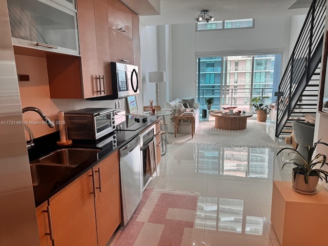 kitchen with light tile patterned floors, stainless steel appliances, and sink