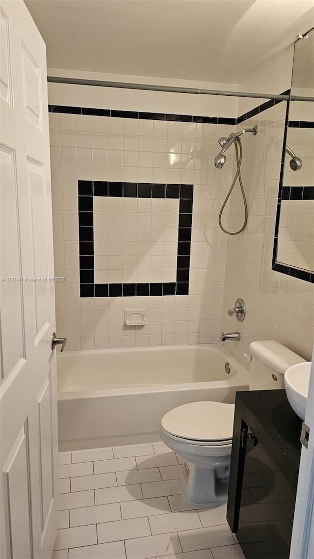 full bathroom featuring tile patterned flooring, vanity, tiled shower / bath combo, and toilet