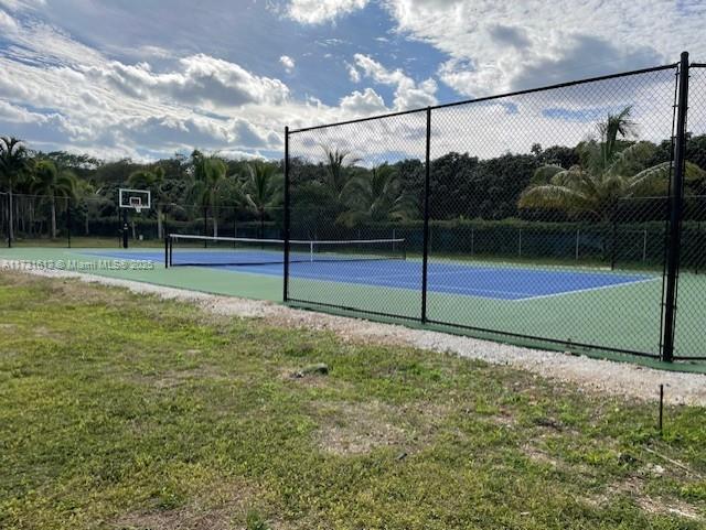 view of sport court with a yard