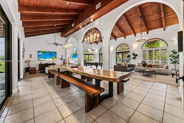 tiled dining space with beamed ceiling, ceiling fan with notable chandelier, wooden ceiling, and high vaulted ceiling