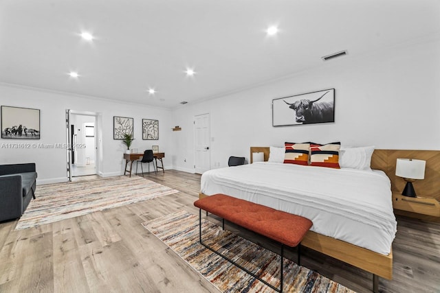 bedroom featuring crown molding and light hardwood / wood-style floors