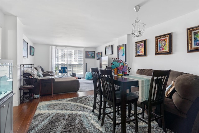 dining room with dark hardwood / wood-style flooring and a notable chandelier