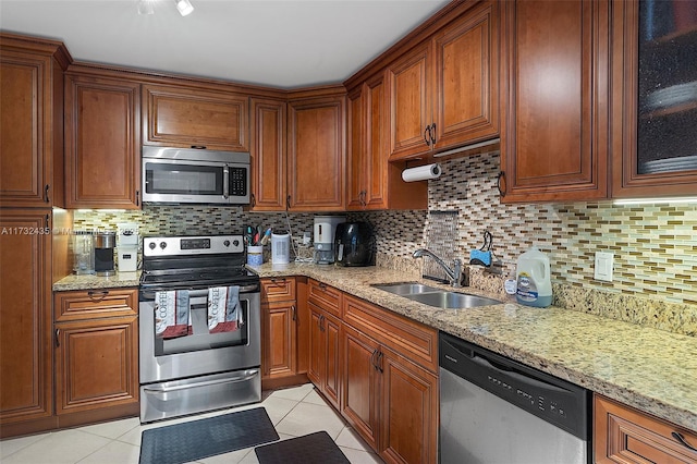 kitchen featuring sink, backsplash, light tile patterned floors, and appliances with stainless steel finishes