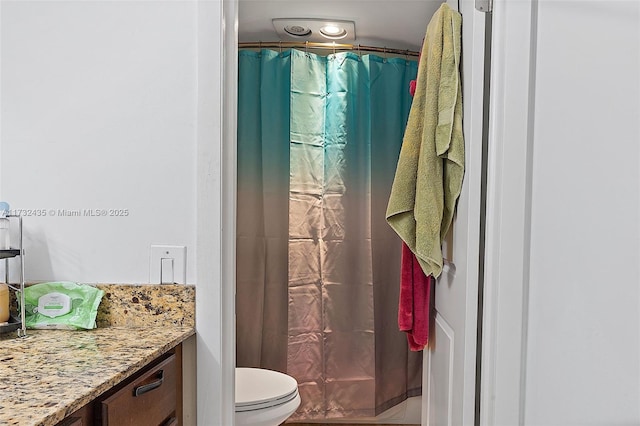 bathroom featuring vanity, toilet, and walk in shower