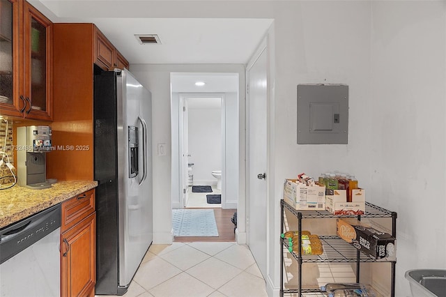 kitchen featuring light stone counters, appliances with stainless steel finishes, electric panel, and light tile patterned floors