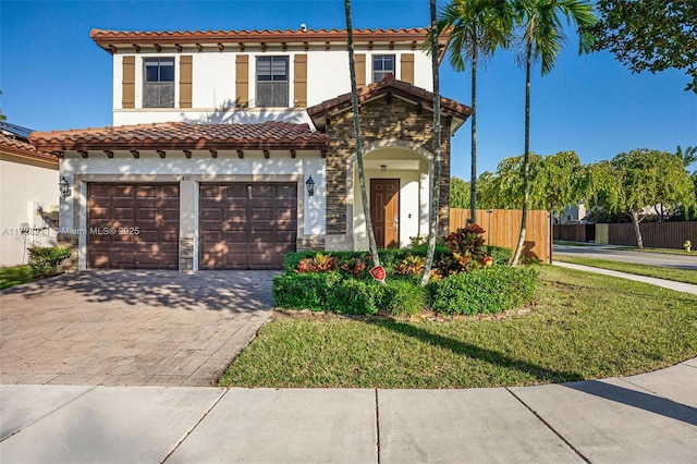 mediterranean / spanish home featuring a garage and a front yard