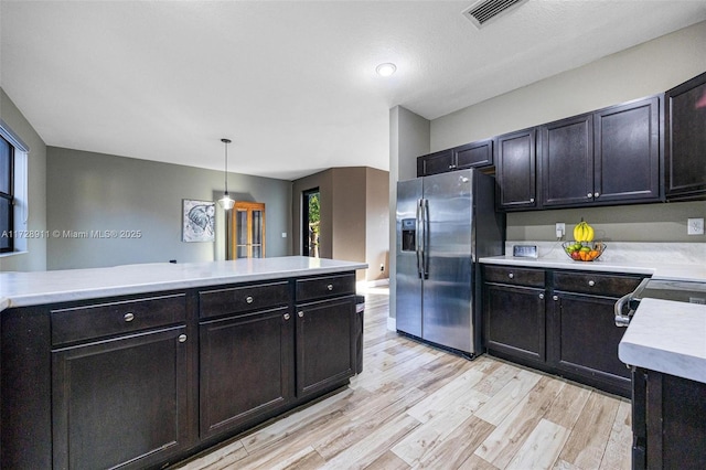 kitchen featuring pendant lighting, stainless steel fridge, and light hardwood / wood-style floors