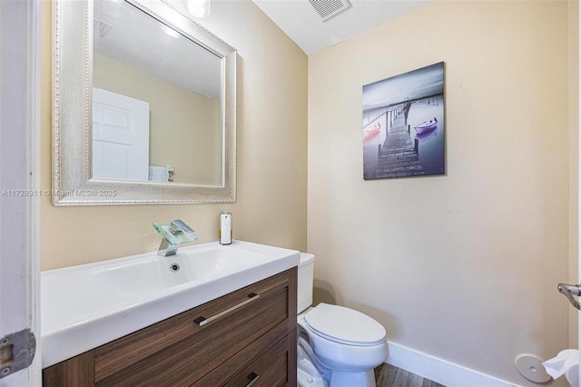 bathroom with vanity, toilet, and wood-type flooring