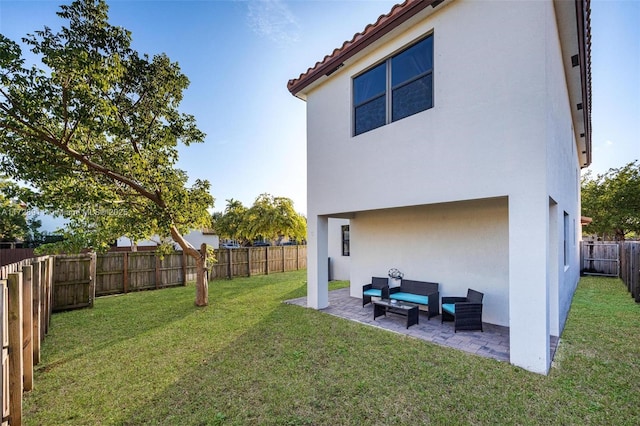 rear view of property featuring an outdoor living space, a lawn, and a patio