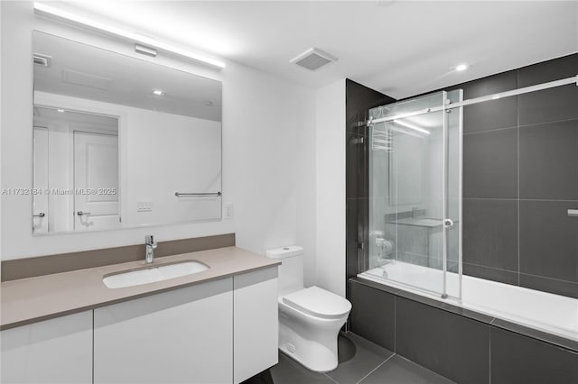 full bathroom featuring toilet, tile patterned floors, vanity, and shower / bath combination with glass door