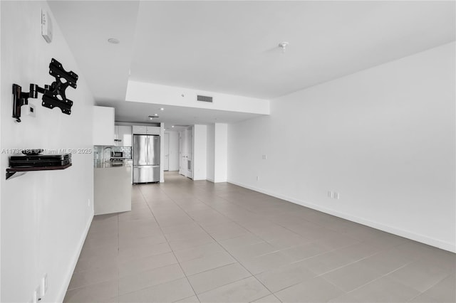 unfurnished room with sink and light tile patterned floors