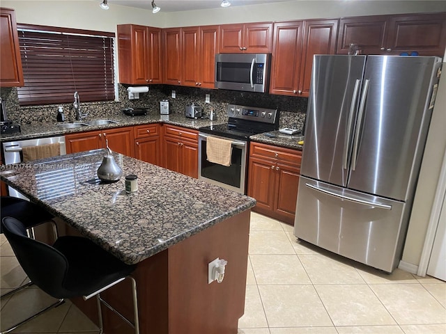 kitchen with sink, a kitchen island, a breakfast bar area, and stainless steel appliances