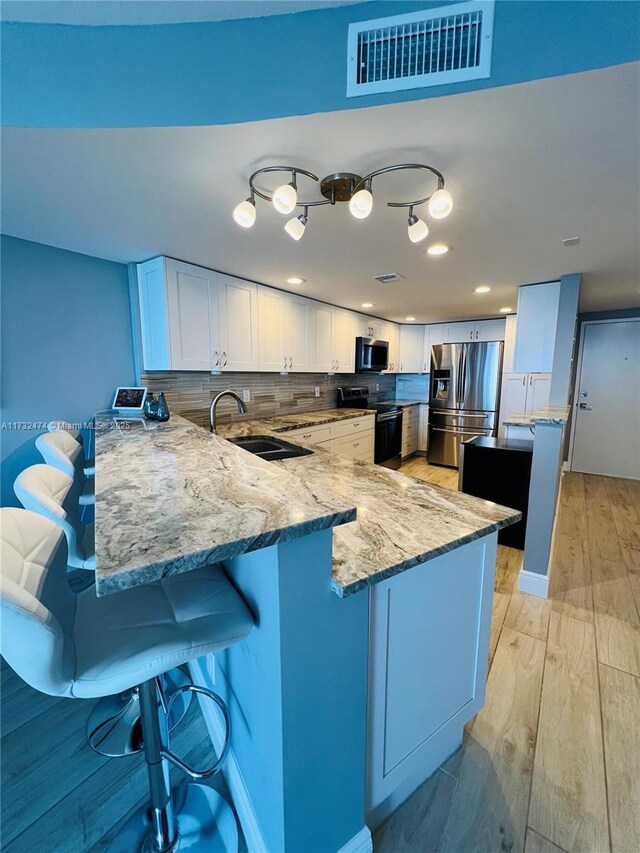 2301 S Ocean Dr Unit 2408, Hollywood, FL 33019 - kitchen featuring visible vents, a sink, a peninsula, and stainless steel appliances