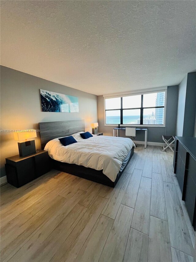 2301 S Ocean Dr Unit 2408, Hollywood, FL 33019 - bedroom with a textured ceiling, baseboards, and wood finished floors