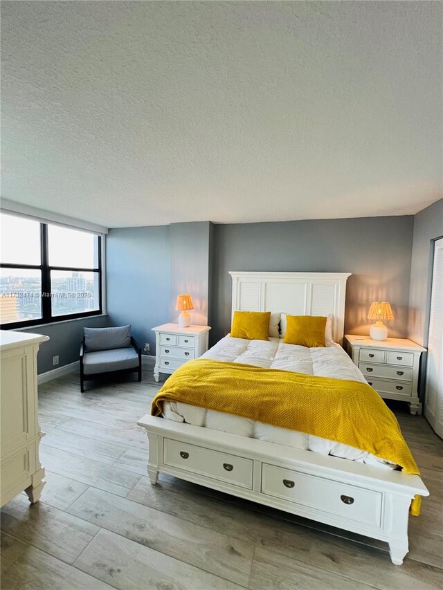 2301 S Ocean Dr Unit 2408, Hollywood, FL 33019 - bedroom with a textured ceiling, light wood-style floors, and baseboards