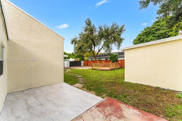 view of yard featuring a wooden deck and a patio