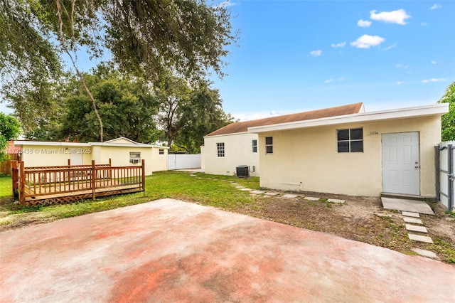 back of property with cooling unit, a yard, a deck, and a patio area