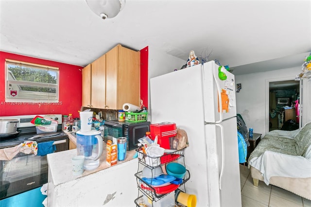 kitchen featuring white refrigerator, tile patterned flooring, and stainless steel range with electric cooktop