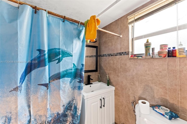 bathroom featuring vanity, curtained shower, tile walls, and toilet