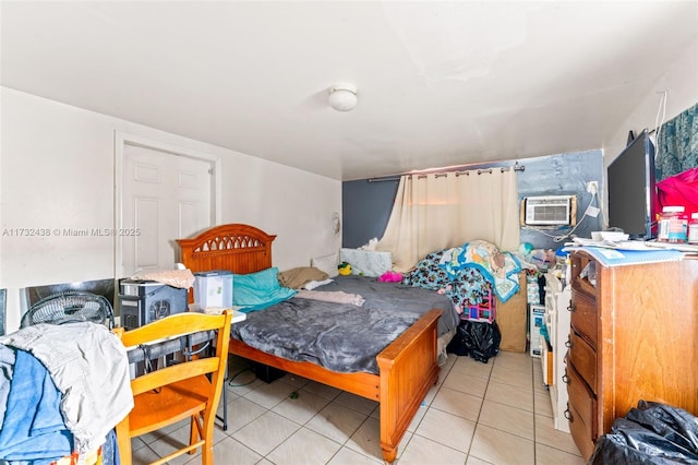 bedroom with light tile patterned floors and an AC wall unit