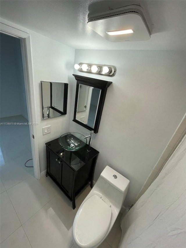 bathroom with toilet, tile patterned flooring, and vanity