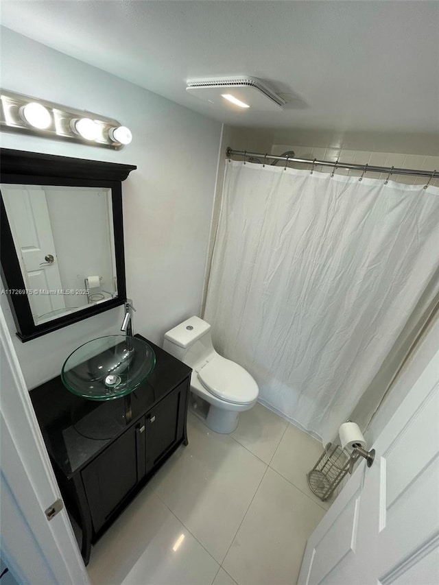 bathroom with toilet, curtained shower, tile patterned flooring, and vanity