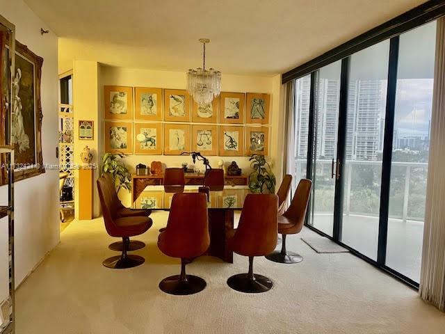 dining space with light carpet, floor to ceiling windows, and a chandelier