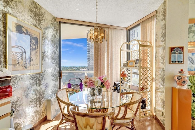 dining area with an inviting chandelier and a textured ceiling