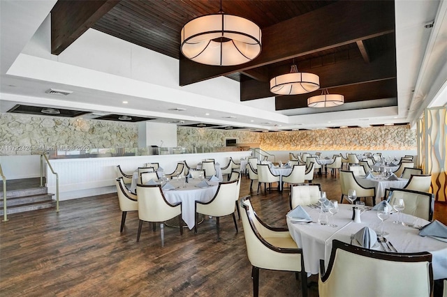 dining area featuring beamed ceiling, wood-type flooring, wooden ceiling, and a tray ceiling