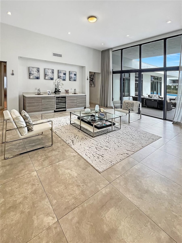 living room featuring wine cooler and a wall of windows