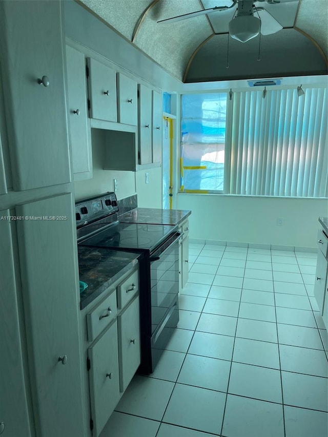 kitchen with white cabinetry, brick ceiling, lofted ceiling, and electric range