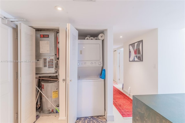 laundry room with stacked washer and clothes dryer and water heater