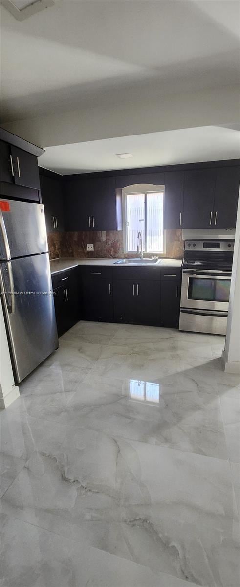 kitchen with sink, decorative backsplash, and appliances with stainless steel finishes