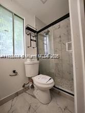 bathroom with toilet and walk in shower