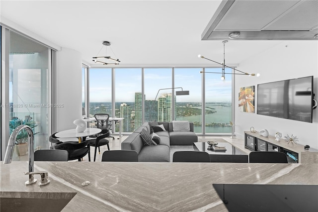 living room with expansive windows, an inviting chandelier, and sink