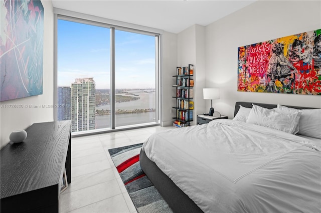 tiled bedroom featuring floor to ceiling windows and a water view