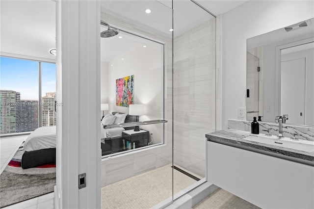 bathroom with vanity, tile patterned floors, expansive windows, and a tile shower